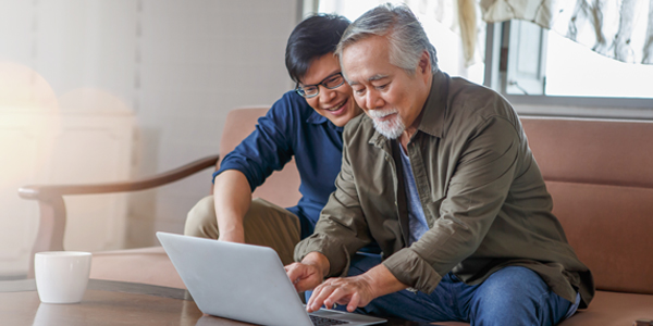 son helping father on laptop